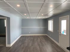 an empty room with hard wood floors and white trim on the ceiling is painted blue