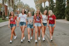 a group of young women walking down the street in short shorts and t - shirts