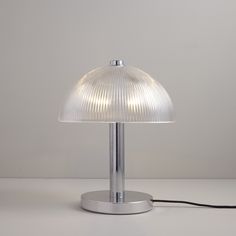 a lamp that is sitting on top of a white tablecloth with a cord attached to it