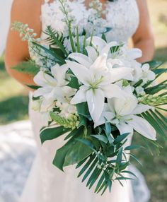 a bride holding a bouquet of white flowers