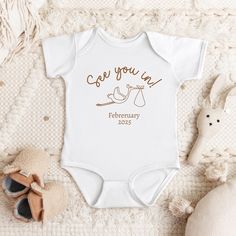 a baby's bodysuit with the words, see you in february on it