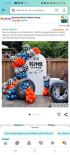 an orange and blue balloon arch next to a white sign with black and silver balloons