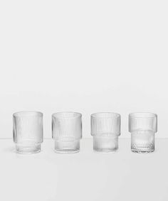 four clear glass cups sitting on top of a table