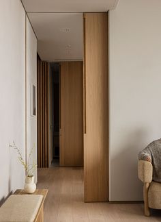 a living room filled with furniture next to a white wall and wooden floored walls