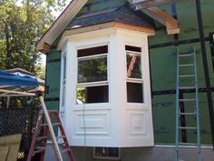 a house being built with windows and ladders