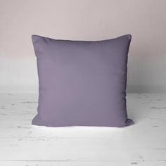 a purple pillow sitting on top of a white floor