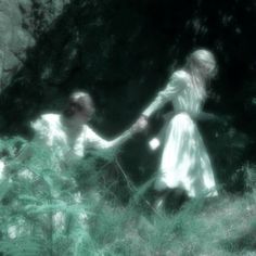 two people are holding hands in the woods