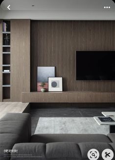 a living room with a couch, television and book shelf in the middle of it