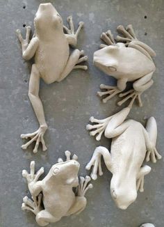 four white frog figurines sitting on top of a table next to each other