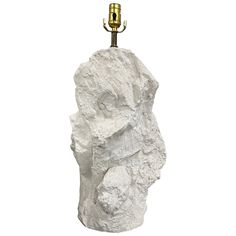 a lamp that is on top of a white rock with a hook in the middle