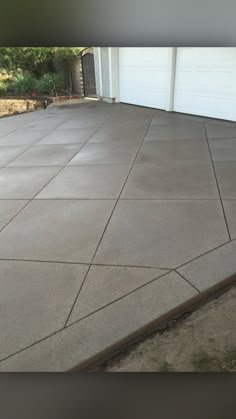 a concrete driveway with a garage door in the background