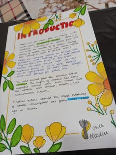 a paper with yellow flowers on it sitting on top of a table next to other papers