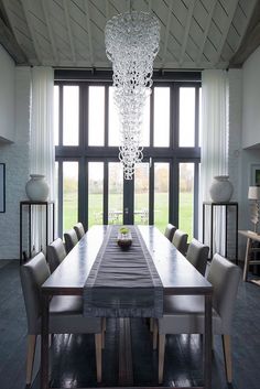 a dining room table with chairs and a chandelier hanging from the ceiling