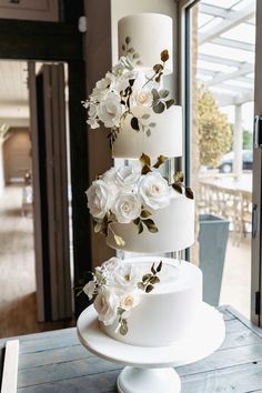 a three tiered wedding cake with white flowers