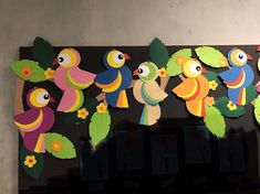 colorful paper cut out birds and leaves on a black background