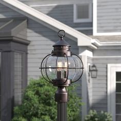 an old fashioned lamp post in front of a house