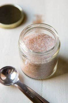 a spoon sitting next to a jar filled with powder