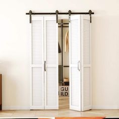 an open closet door with white shutters on the inside and outside, in a living room