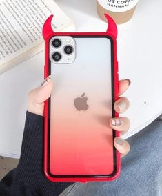 a person holding up an iphone case with horns on the front and back cover in red