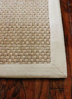 a close up of a rug on a wooden floor with a white border around it