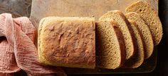 a loaf of bread sitting on top of a cutting board next to slices of bread