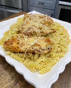 two pieces of chicken covered in cheese on top of pasta