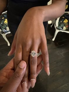 a man and woman holding hands with their wedding rings on top of each other's fingers