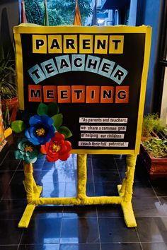 a sign that says parent teacher meeting with flowers on the front and side of it