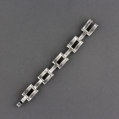 This is a great Mid Century Modernist Mexican Taxco sterling silver hidden closure link bracelet. The sterling bracelet has ten slightly curved hinged sections. The design alternates between one and then two pieces. They are connected by a pin and the movement is supple and easy. There is a incised line and circle pattern on each piece. The bracelet has a hook and bar clasp that is hidden when worn. The silver is even, and any variance is a reflection. A nice size, as worn it measures 7 3/8 inch Modern Sterling Silver Jubilee Bracelet With Rectangular Links, Modern Sterling Silver Bracelet With Solid Link Construction, Modern Sterling Silver Link Bracelet, Modern Polished Sterling Silver Bracelet, Modern Sterling Silver Bracelet With Rectangular Links, Modern Chain Bracelet With Rectangular Links, Modern Sterling Silver Bracelet For Formal Occasions, Formal Modern Sterling Silver Bracelet, Modern Link Bracelets With Polished Finish