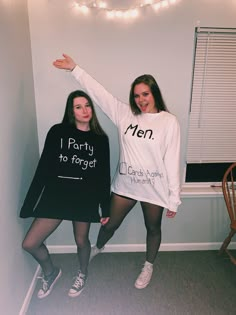 two women standing next to each other wearing matching sweatshirts