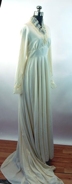 "This 1960s wedding gown is a lovely creation by Edythe Vincent for Alfred Angelo. It features a pretty, sheer crystal pleated ruffle at the neck and sleeves with ivory lace. There are covered buttons up the back and at the ends of the sleeves. The bust is gathered to a high panel waist. The material is an ivory polyester that has a beautiful drape. The train is a dramatic 10 feet long. Very good condition. No flaws noted. Measurements - Shoulder - 15\" Bust - 32\" Waist - 25\" Sleeves - 23\" fr Eyelet Wedding Dress, Waist Wedding Dress, Empire Waist Wedding Dress, 1960s Wedding, Kimono Wrap Dress, Vintage Wedding Photos, Alfred Angelo, Special Occasion Outfits, Long Train