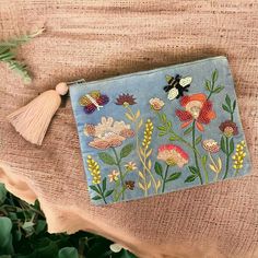 a blue purse with flowers and butterflies on it