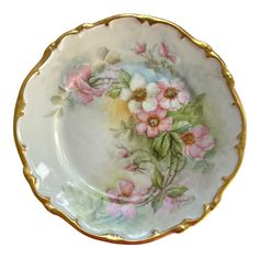 a white and gold plate with pink flowers on it