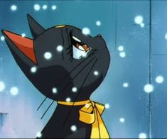 a black cat wearing a yellow scarf and standing in the snow with its eyes closed