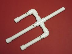 three white plastic pipes on a red surface