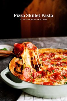 a pizza is being lifted with a spatula from a casserole dish on a table