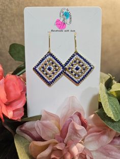 the earrings are on display next to some flowers