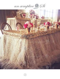 the table is covered with gold sequins and pink flowers