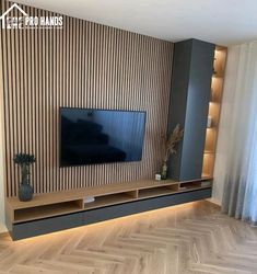 a living room with wood flooring and a tv on the wall in front of it