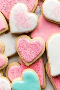 heart shaped cookies with pink, blue and white frosting on top are arranged in the shape of hearts