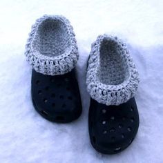 a pair of black and white crocheted shoes in the snow