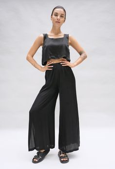 Model is posing in a studio. She is wearing a black crop top and matching wide leg pant in a black silky fabric by Fauna The Label. Versatile Wide Leg Viscose Pants With Elastic Waistband, Versatile Viscose Wide Leg Pants With Elastic Waistband, Versatile High-waisted Viscose Pants, Stretch High-waisted Viscose Pants, Ankle-length Solid Viscose Wide Leg Pants, Versatile Ankle-length Viscose Wide Leg Pants, Stretch Viscose Straight Leg Pants, Versatile Straight Leg Viscose Bottoms, Solid Wide-leg Viscose Pants