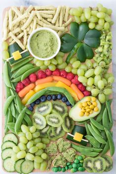 a wooden board topped with lots of different fruits and vegetables