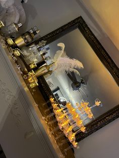 a mirror with some lights in front of it on the wall next to a chandelier