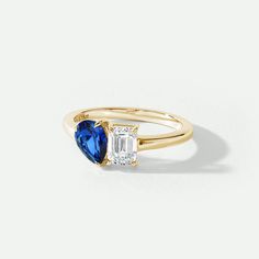 a gold ring with two blue and white stones on the side, set in 18k yellow gold