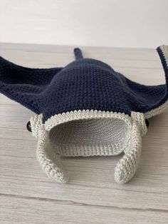 a crocheted blue and white hat sitting on top of a wooden table