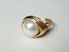 Pearl Ring Large White Swarovski Glass pearl wrapped in 14k gold filled wire. This is a large glass bead approximately 10-12mm. Beautiful large white pearl surrounded in gold. 14K Gold Pearl ring makes a wonderful Mothers Day Gift! Ring sizes available 3-16. Ring can be custom sized 1/2 or 1/4 sizes. Please provide correct sizing in drop down box in shop listing. Once made this ring type can not be re-sized. SIGN UP FOR OUR EMAIL LIST FOR 10% OFF Copy and past URL in your browser http://eepurl.c Gold Pearl Rap Around Ring, Gold Hallmarked Pearl Ring For Gift, Classic 14k Gold Hallmarked Pearl Ring, White Wire Wrapped Pearl Ring For Wedding, Elegant White Wire Wrapped Pearl Ring, Gold Wire Wrapped Pearl Ring Gift, Adjustable Wire Wrapped Pearl Ring, Gold Pearl Ring, Gold Filled Ring