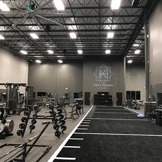 an empty gym with equipment in the middle and lights above it that are lit up