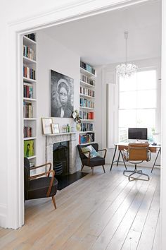 a living room filled with furniture and a fire place in front of a book shelf