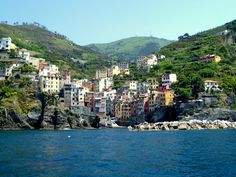 some buildings on the side of a hill by the water